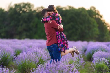Gün batımında lavanta tarlasında harika vakit geçiren genç bir çift.