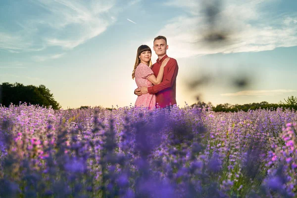日没時にラベンダー畑で素晴らしい時間を過ごしている素敵な若いカップル — ストック写真
