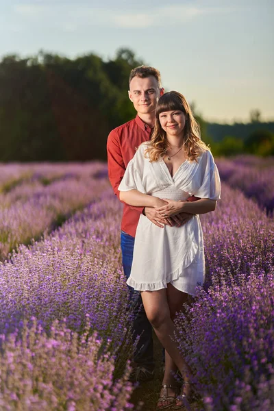 Gün batımında lavanta tarlasında harika vakit geçiren genç bir çift.
