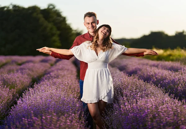 Gün batımında lavanta tarlasında harika vakit geçiren genç bir çift.
