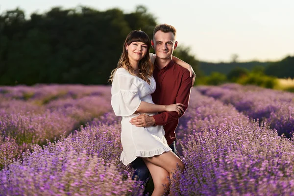 Gün batımında lavanta tarlasında harika vakit geçiren genç bir çift.