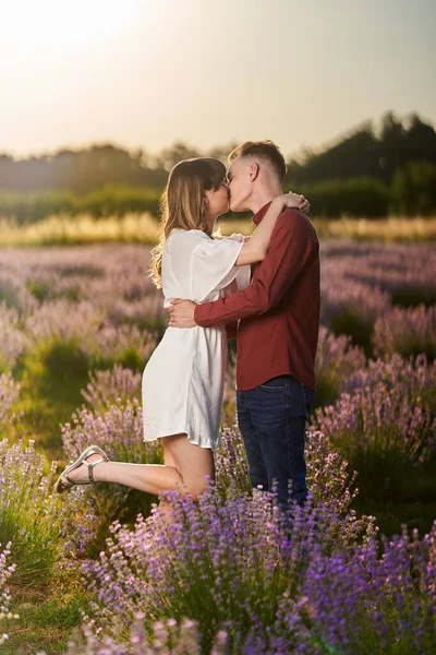 Gün batımında lavanta tarlasında harika vakit geçiren genç bir çift.