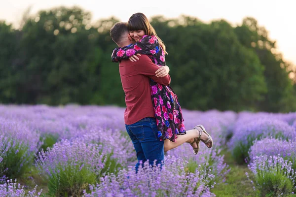 Gün batımında lavanta tarlasında harika vakit geçiren genç bir çift.