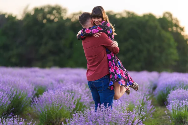 Gün batımında lavanta tarlasında harika vakit geçiren genç bir çift.