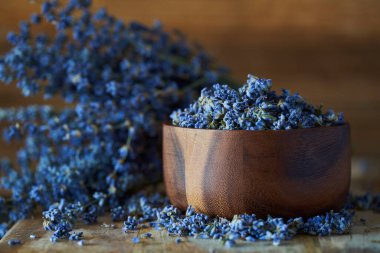 Kırsal ahşap bir tahtanın üzerindeki kasede duran taze lavanta çiçekleri.