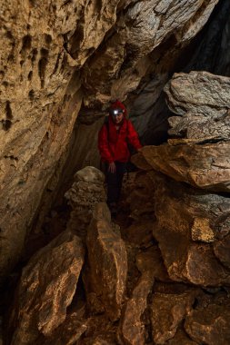 Woman with headtorch exploring a very old cave with beautiful speleothems