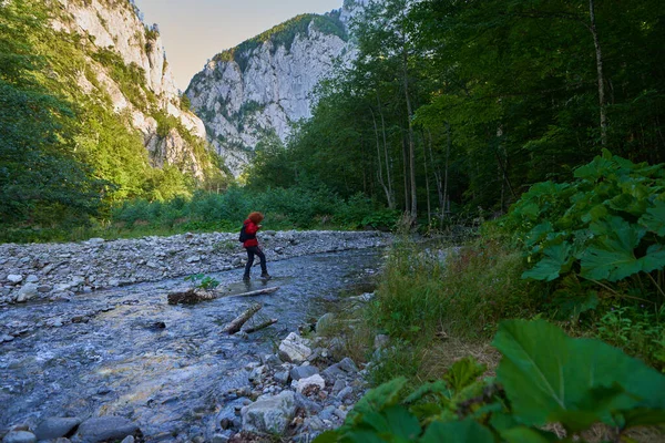 Woman Hiker Backpack Crossing River Mountains — Stockfoto