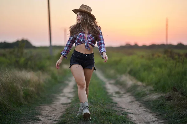 Bela Vaqueira Chapéu Camisa Xadrez Jeans Curtos Pôr Sol Campo — Fotografia de Stock