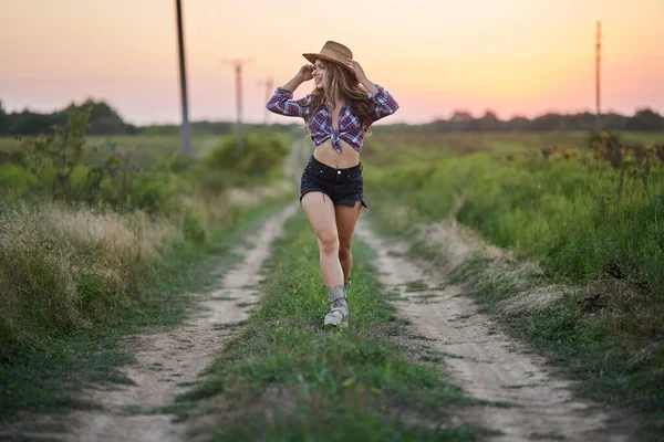 Gyönyörű Cowgirl Kalapban Kockás Ingben Rövid Farmerban Naplementekor Egy Vidéki — Stock Fotó