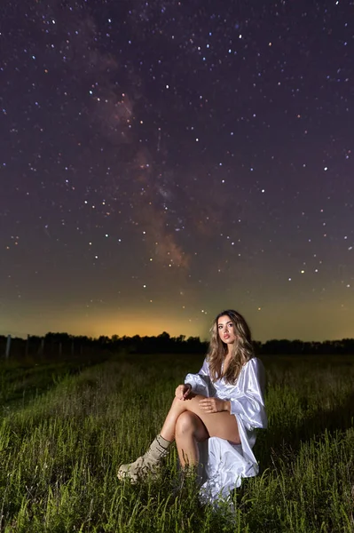 漂亮的女人穿着白色的衣服 背景是银河系 夜间拍摄 — 图库照片