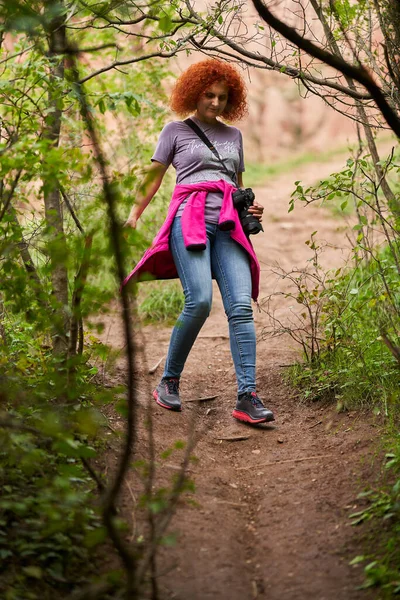 Fotógrafo Ruiva Cabelo Encaracolado Mulher Caminhando Floresta Com Sua Câmera — Fotografia de Stock