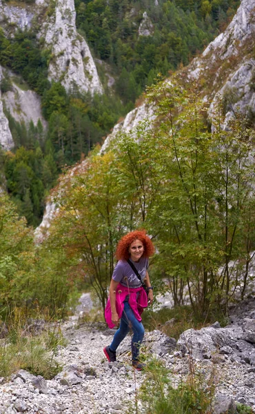 山の中の急な歩道にカメラのハイキングと巻き毛の観光客の女性 — ストック写真