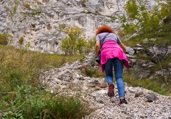 Turistka Kudrnatými Vlasy Kamerou Turistika Strmé Stezce Horách — Stock fotografie