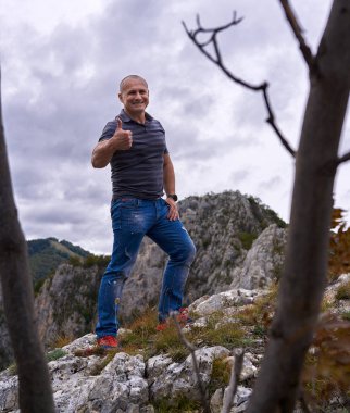 Kayalık dağların tepesindeki atletik adam