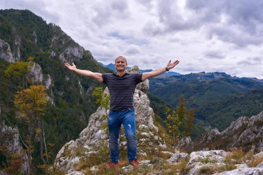 Kayalık dağların tepesindeki atletik adam