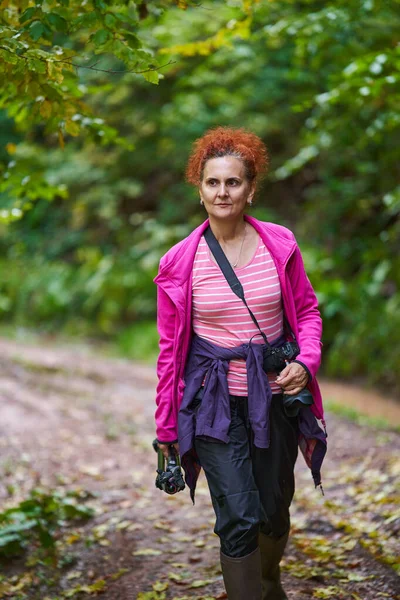 自然女摄影师拿着相机到山林里去远足 — 图库照片