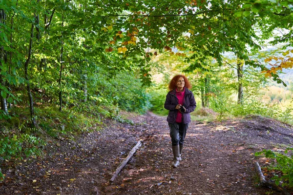 Mulher Ruiva Com Cabelo Encaracolado Câmera Caminhadas Uma Trilha Floresta — Fotografia de Stock