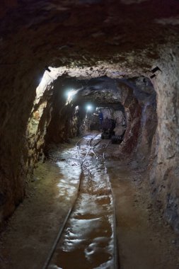 Terk edilmiş bir madenden aydınlatılmış bir tünel.