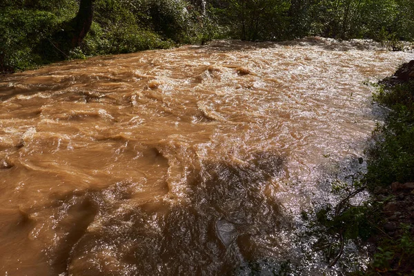 River flooding with muddy waters making rapids and waves