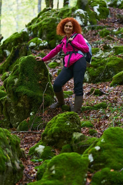 野生の森の中の赤い頭の女性のハイキング ストック画像
