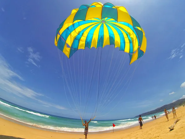 Man bereidt een parachute voor toeristen op het strand — Stockfoto