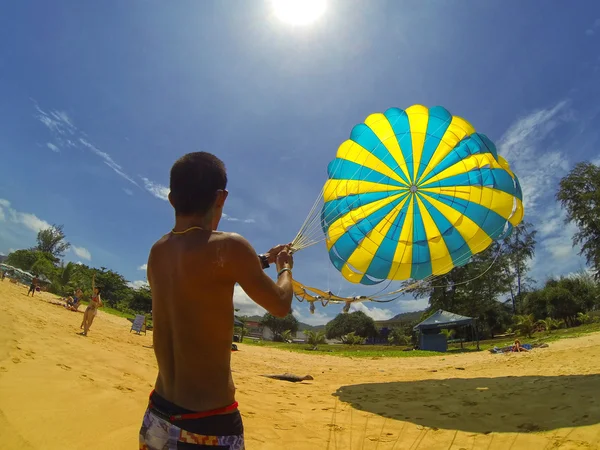 Man prepares a parachute for tourists on the beach — Stock Photo, Image