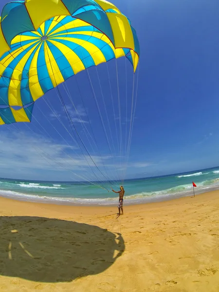 Man prepares a parachute for tourists on the beach — Stock Photo, Image