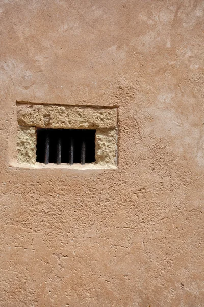 Vecchia finestra su un muro di pietre chiare — Foto Stock