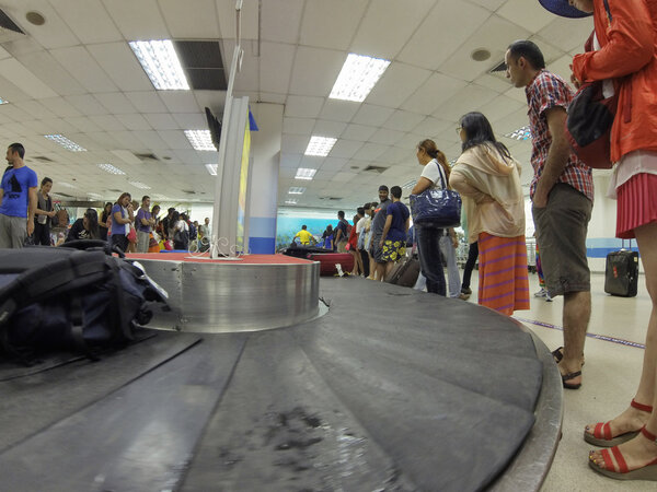 People waiting for their bags at airport conveyor belt