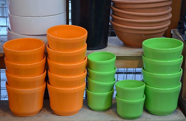 Colorful flowerpots on the shelf — Stock Photo, Image