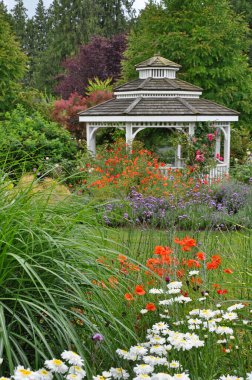 White wooden gazebo in beautiful summer botanical garden
