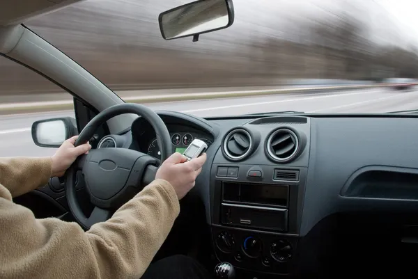 Conducteur utilisant un téléphone portable dans la voiture mouvement flou — Photo