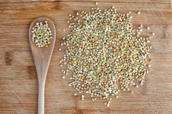 Organic green buckwheat on wooden table — Stock Photo, Image