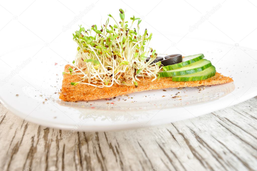 Sprouted grains of alfalfa with cucumbers, olives and a slice of