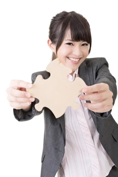 Asiatische Geschäftsfrau hält ein Puzzleteil in der Hand. — Stockfoto
