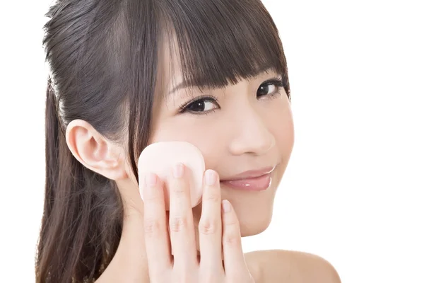 Gyönyörű ázsiai nő arca kozmetikai szivacs segítségével. — Stock Fotó