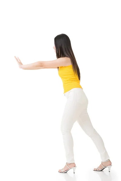 Pretty young asian woman pushing or leaning on wall. — Stock Photo, Image