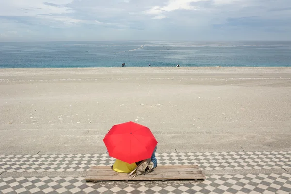 Пара на пляже под зонтиком — стоковое фото