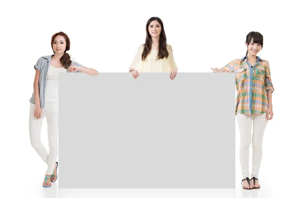 Three pretty women showing an empty board — Stock Photo, Image