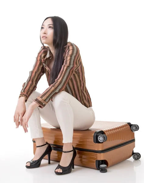 Asian woman thinking and sitting on a luggage — Stock Photo, Image