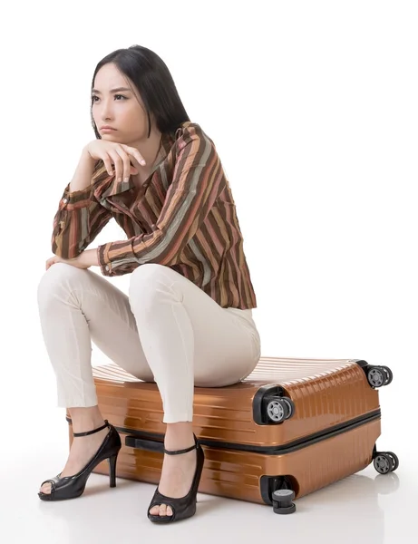 Asian woman thinking and sitting on a luggage — Stock Photo, Image