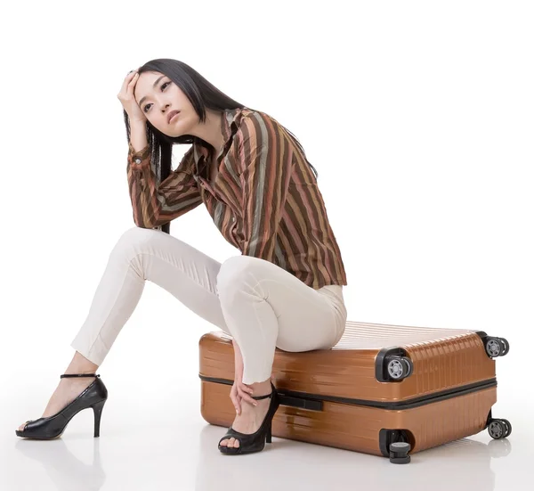 Asiática mujer pensando y sentado en un equipaje — Foto de Stock