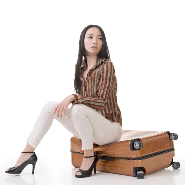 Asian woman thinking and sitting on a luggage — Stock Photo, Image