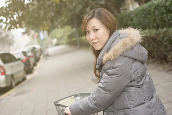 Genç Asyalı kadın binicilik bisiklet — Stok fotoğraf