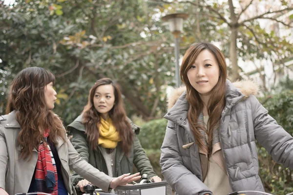 年轻的亚裔女子骑着自行车和朋友一起 — 图库照片