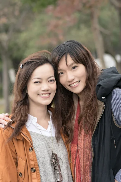 Счастливые улыбающиеся азиатки в парке — стоковое фото
