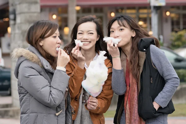 Gelukkig jonge Aziatische vrouw eten suikerspin met haar vrienden — Stockfoto
