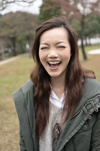 Счастливая улыбающаяся азиатская молодая женщина в парке — стоковое фото