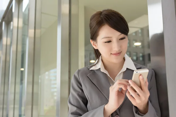 Junge Geschäftsfrau benutzt Handy — Stockfoto