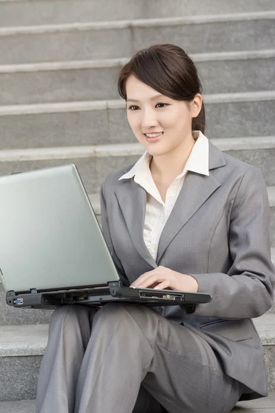 Dizüstü bilgisayar kullanan mutlu gülümseyen iş kadın — Stok fotoğraf